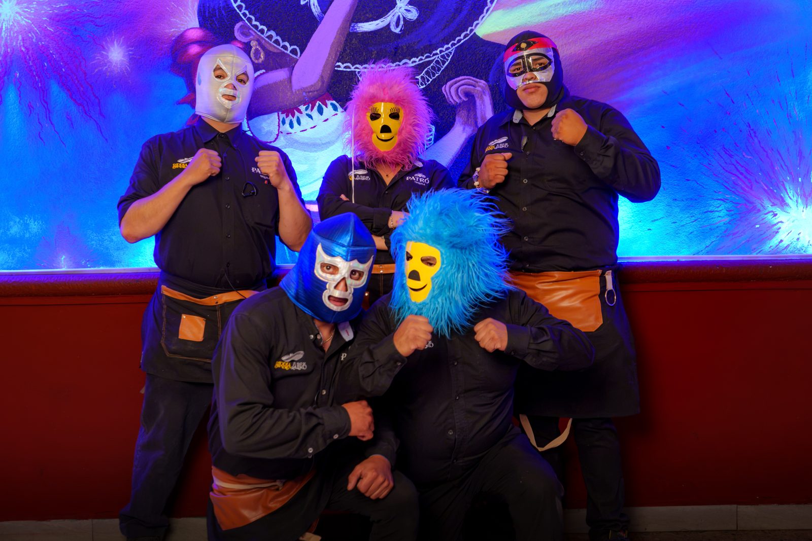 El equipo con máscaras de luchador frente al mural