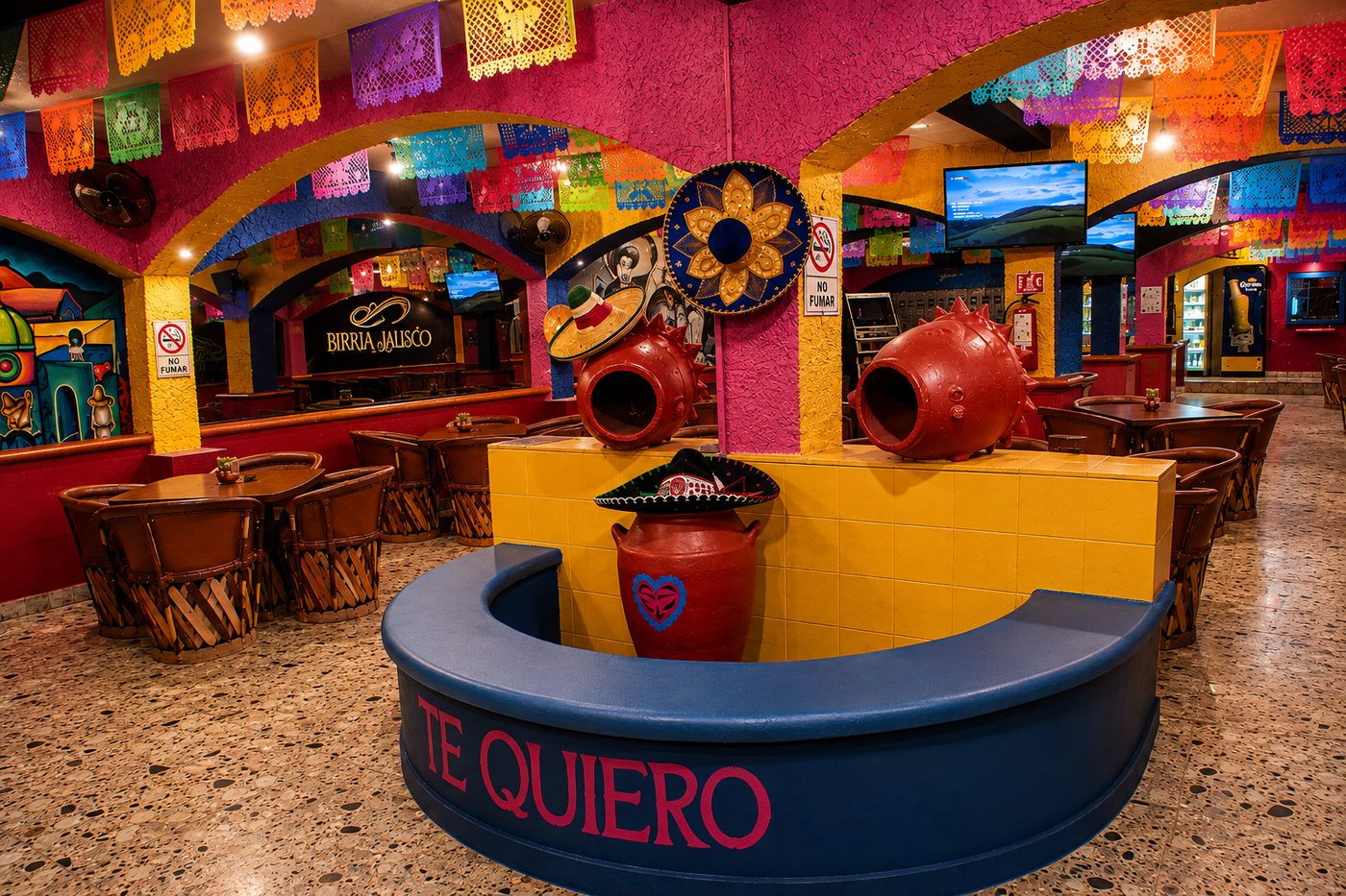 Salón de la planta baja con arcos, papel picado y la fuente Te Quiero