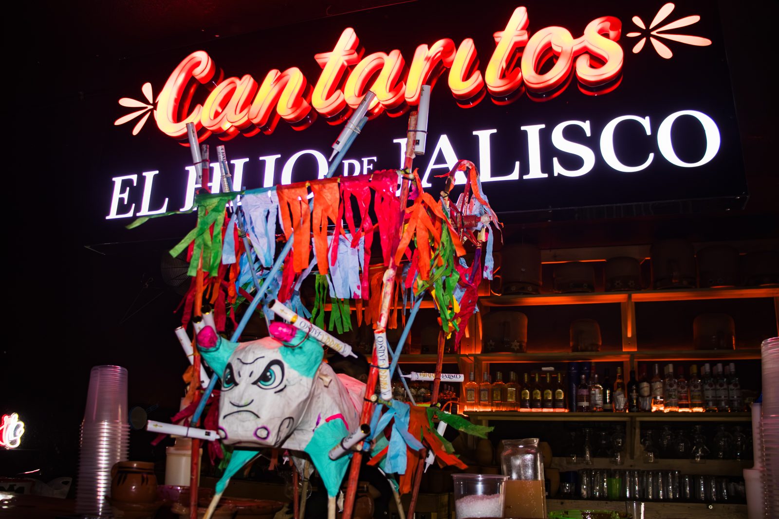 Piñata lista frente al neón de Cantaritos