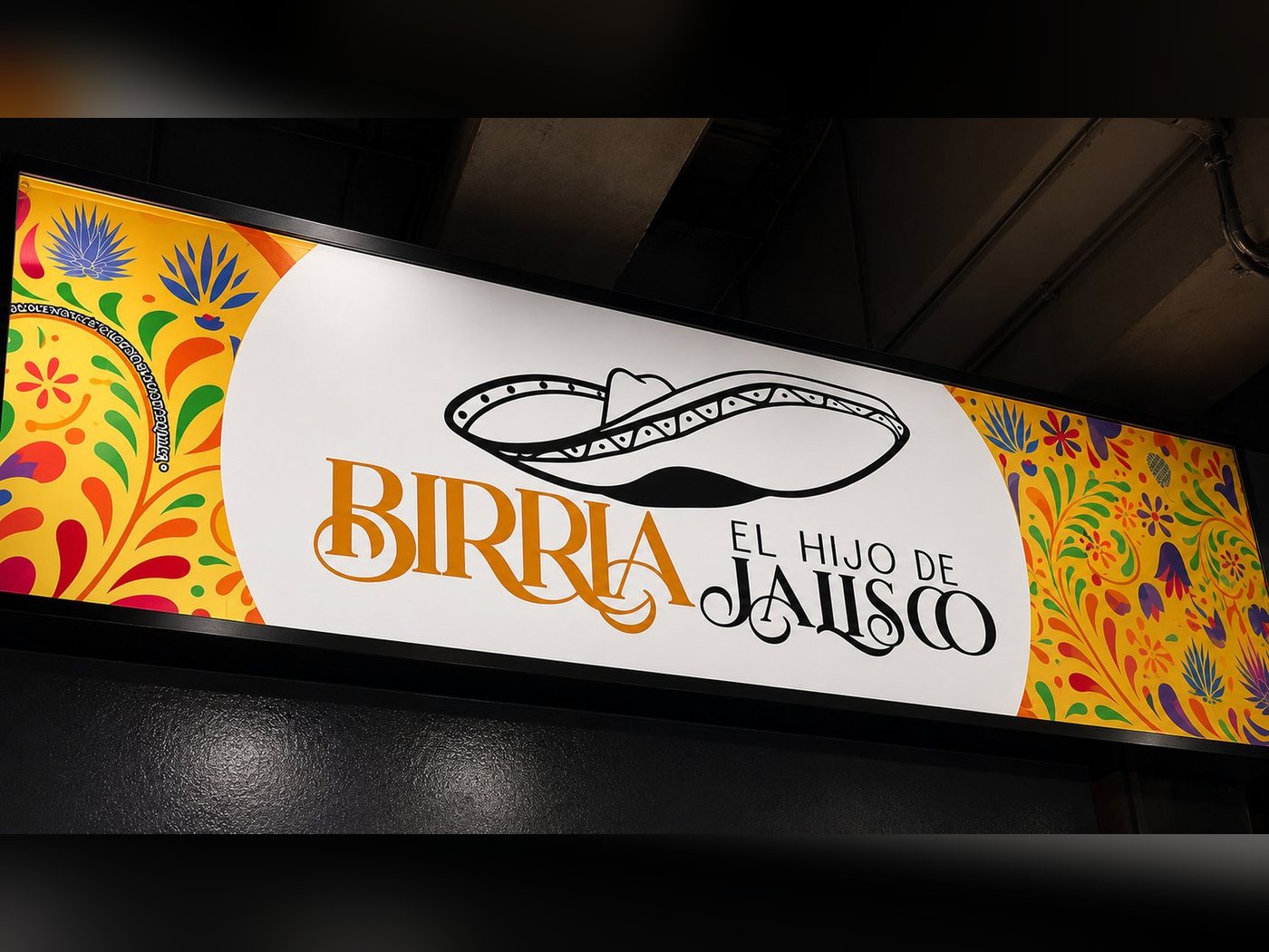 Letrero de Birria El Hijo de Jalisco bajo el puente