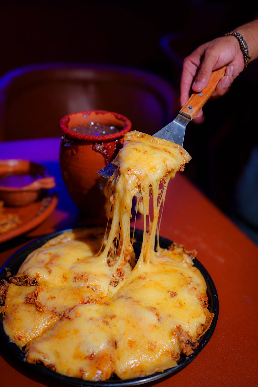 Queso fundido jalando desde la espátula