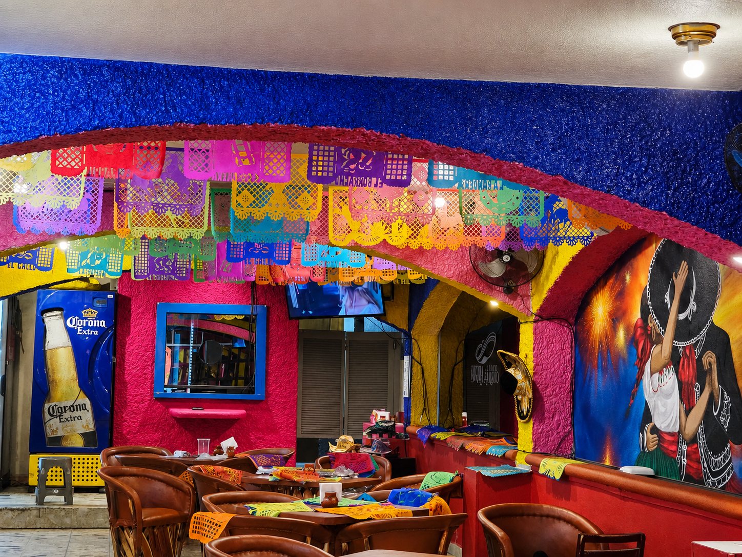 Interior del salón familiar con murales y papel picado