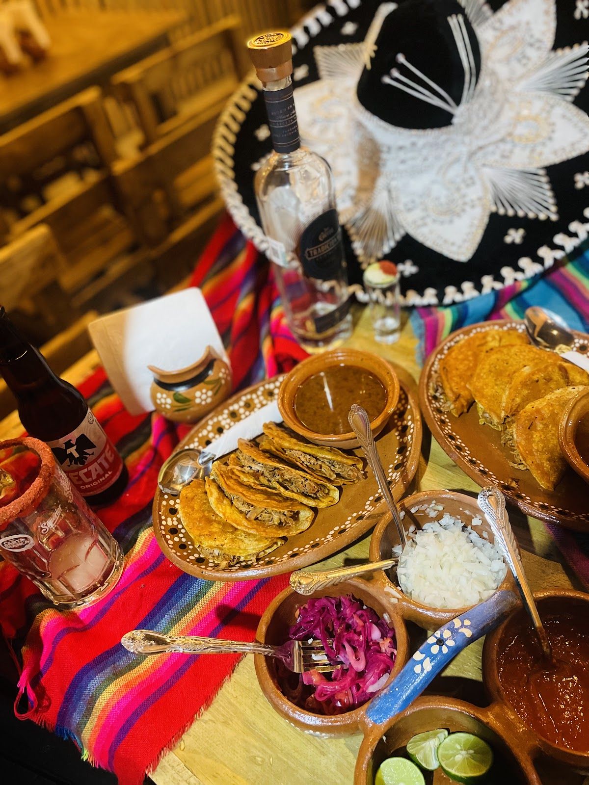 Mesa servida con birria, salsas y guarniciones