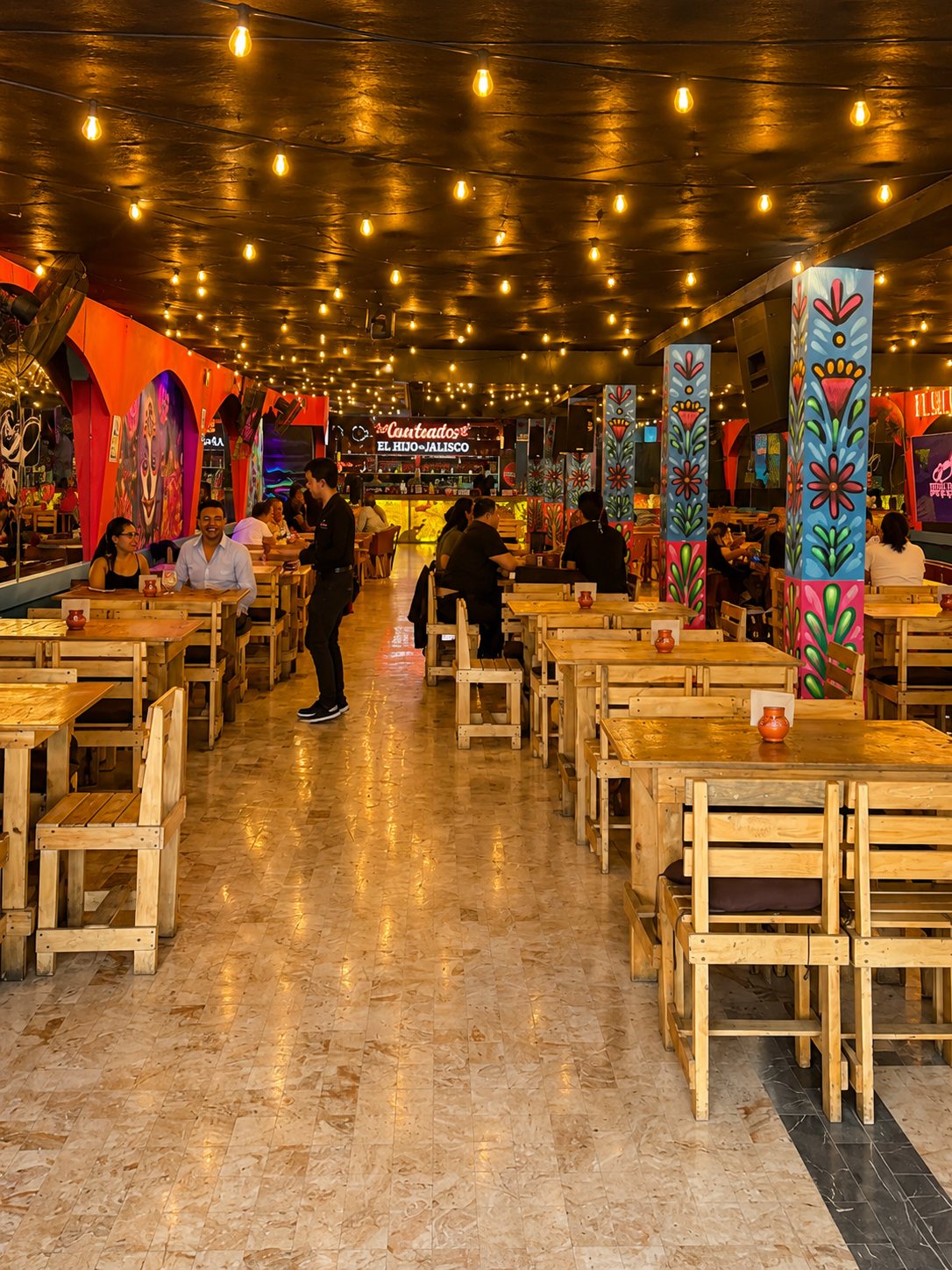 Salón amplio de la planta baja con mesas de madera